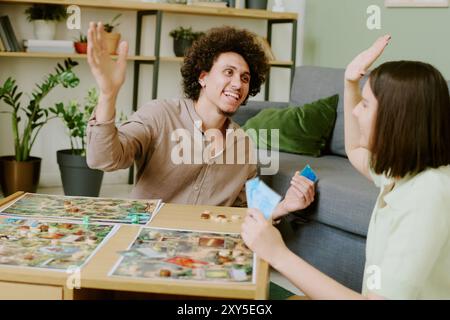 Couple Doing High Five While Playing Board Game Stock Photo