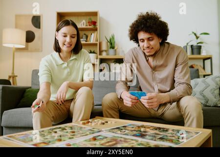 Happy Young Couple Playing Tabletop Game Stock Photo