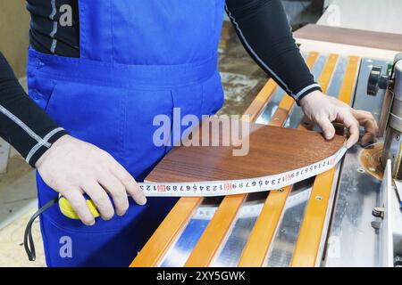 Closeup of Carpenter's hands using one meter in a cottage workshop Stock Photo