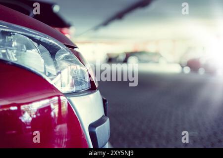 The front part of a car in the light of the low sun under a covered car park Stock Photo