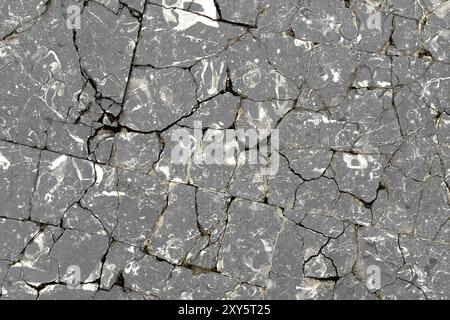 Broken cracked granite exterior block floor as abstract gray background close up Stock Photo