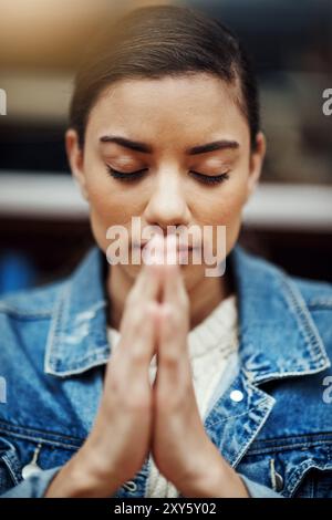 Woman, praying and spiritual in university for study, worship and college scholarship in library. Student, learning and meditation to God on campus Stock Photo