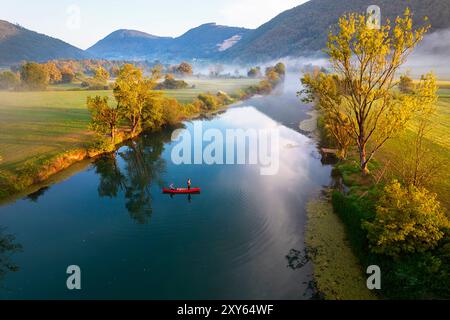 Tourists, father and son, fishing from a canoe, boat, on a beautiful morning at sunrise time on a Krka river in Dolenjska region, SLovenia Stock Photo