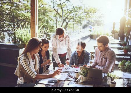 Business, group and notes in meeting, cafe and ideas for project, graph and laptop with stats. Writing, SEO and teamwork of people with planning Stock Photo