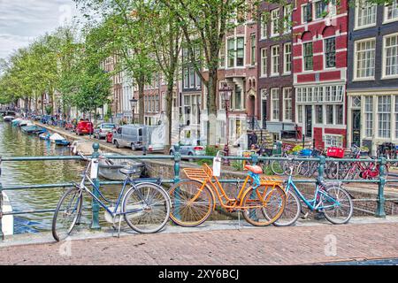 AMSTERDAM, NETHERLANDS - JULY 10, 2017: People visit Herengracht canal in Amsterdam, Netherlands. Amsterdam is the capital city of The Netherlands. Stock Photo