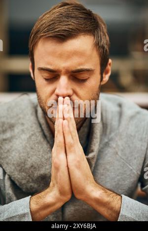 Student, praying and spiritual in university for learning, worship and college scholarship in library. Man, study and meditation to God on campus for Stock Photo