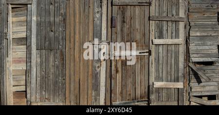 Home wall and door handmade from old worn wood, planks and rusty nails, grunge wooden background, Stock Photo