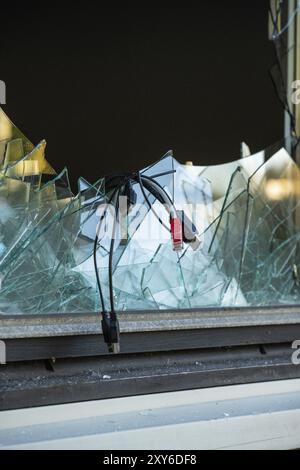 Computer cables hanging out of a broken window after a break in and theft Stock Photo