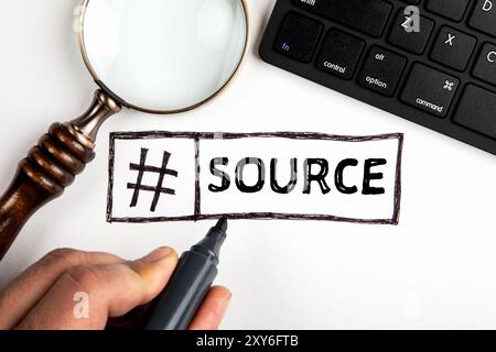 Source. Magnifying glass and computer keyboard on office table. Stock Photo