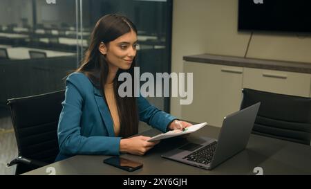 Indian smiling business woman talking to laptop computer web camera video call conference speaking at webcam online chat negotiation meeting Stock Photo