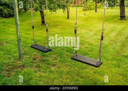Children swings in a empty park or garden Stock Photo