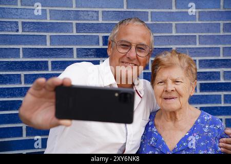 Senior mother and son taking a selfie with their mobile. together in the family Stock Photo