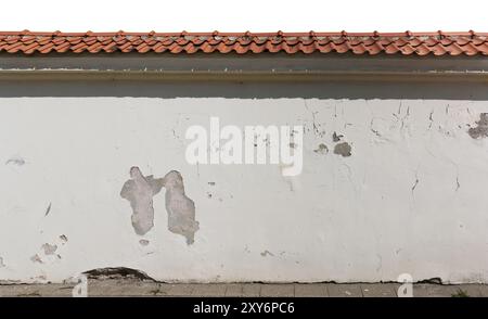 Ancient ruined plastered fence  with  tiled roof. Isolated on white Stock Photo