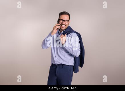 Successful happy businessman with blazer talking with client over mobile phone on white background Stock Photo