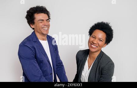 Portrait of male and female professionals smiling cheerfully while standing on white background Stock Photo