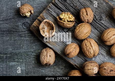 Ripe and raw whole big walnut kernel with shell on rustic backdrop. healthy nut food for brain Stock Photo