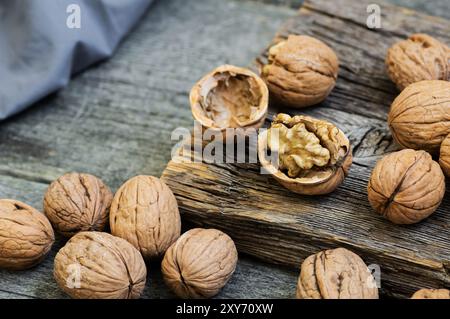 Ripe and raw whole big walnut kernel with shell on rustic backdrop. healthy nut food for brain Stock Photo