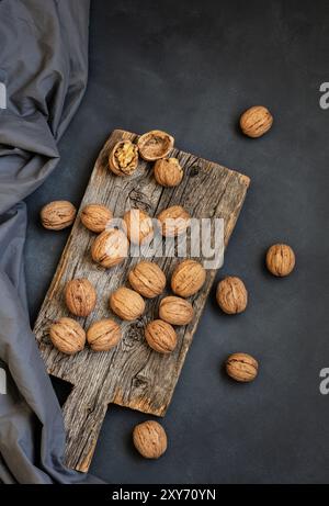 Ripe and raw whole big walnut kernel with shell on rustic backdrop. healthy nut food for brain Stock Photo