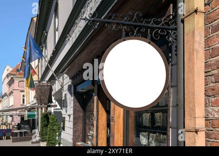 Mockup Of Blacksmith Style Antique Shop Signboard On The Street Of The Old Town. Blank Round Store Sign Hanging On The Wall Stock Photo