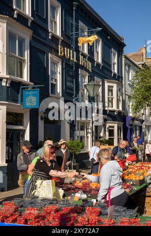 UK England, Dorset, Bridport, East Street, Saturday market, customers at roadside fruit and Veg stall outside Bull Hotel Stock Photo