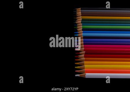 School supplies neatly arranged on a black background, wooden pencil crayons Stock Photo