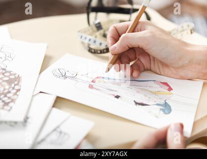 Dressmaker is drawing a fashion sketch. Close up of the hands Stock ...