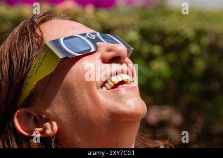 Mexico City, Mexico; 04 08 2024; A woman watching the total solar eclipse with a pair of solar glasses. Stock Photo