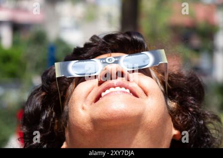 Mexico City, Mexico; 04 08 2024; A woman watching the total solar eclipse with a pair of solar glasses. Stock Photo