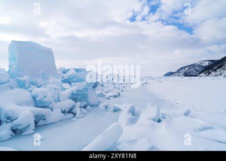 Row of ice blocks and the mountain covering with snow at lake Baikal in Russia in the winter Stock Photo