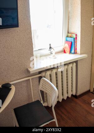 Shot of the small work desk in tiny room. Stock Photo