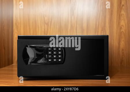 Safe lock code on safety box bank Protection. Small black metal safe box in the hotel room, metal heavy security cash safe. Box security black lock di Stock Photo