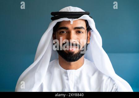 Arab man wearing traditional emirate clothing  working in the office - Middle eastern businessman portrait Stock Photo
