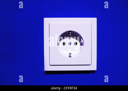 New socket on blue-painted wall Stock Photo