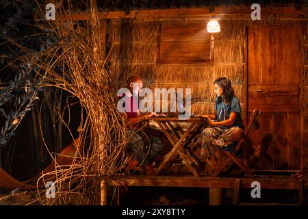 Close up young caucasian hipster couple sit use computer freelance do freelancing work, write travel blog or browse internet search, work online while Stock Photo