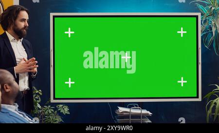Startup team using greenscreen interactive board in a strategy workshop meeting, working together to improve their skills and performance. Corporation employees prepare for collaboration. Camera A. Stock Photo
