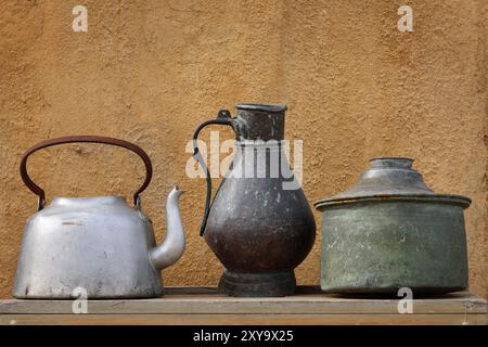 Various metallic pots displayed on a wooden table. Stock Photo