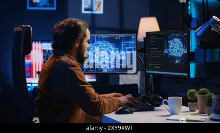 Software developer writes code on multimonitor setup PC to visualize artificial intelligence neural networks. Teleworking IT employee runs AI script on computer from home office, camera A Stock Photo