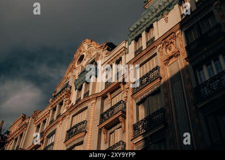 Madrid, Spain. July 1, 2024 View from bottom to top of the facade of a residential old multi-story building beautifully decorated with stucco. Stock Photo