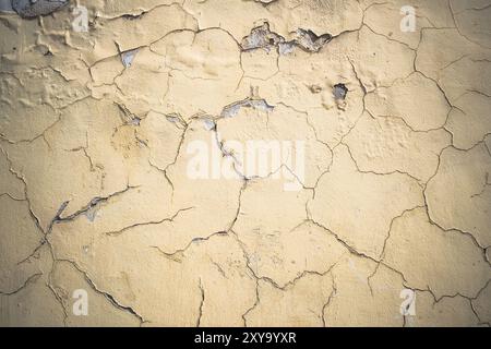 Abstract grunge wall background. Old plastered wall with many cracks. Grungy texture with deep pattern on yellow painted wall Stock Photo