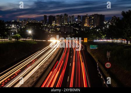 Trail of light caused by vehicular traffic in SP-294, Comandante Joao Ribeiro Barros Highway with buildings from downtown in the background, in Maríli Stock Photo