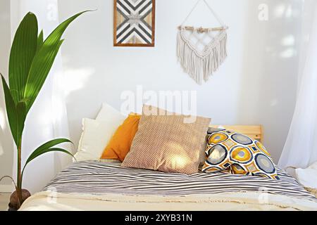 White and beige bedroom in boho style with macrame on the wall Stock Photo