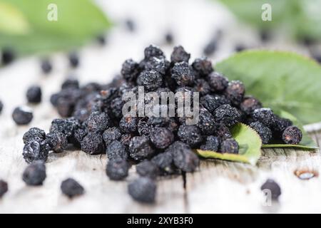 Portion of dried Chokeberries (with leaves) on weatheres wooden background Stock Photo