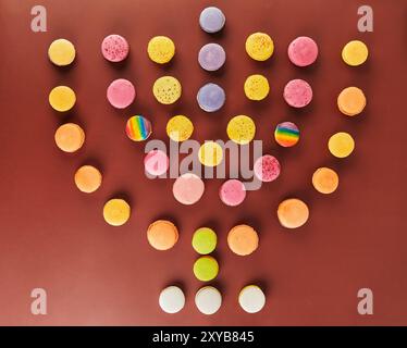 A Hanukkah menorah is laid out with colorful pasta on a brown surface to celebrate the holiday. Stock Photo