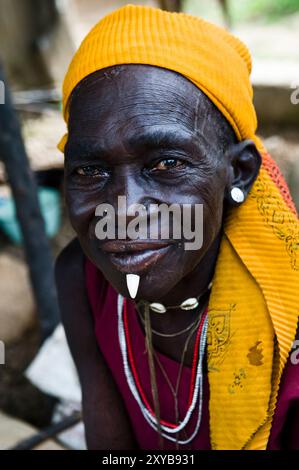 A tribal woman with a wild boar tooth inserted to her lower lip. Photo taken in northern Togo. Stock Photo