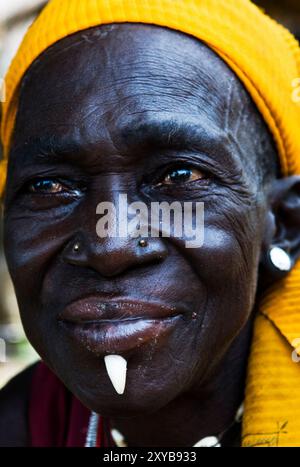 A tribal woman with a wild boar tooth inserted to her lower lip. Photo taken in northern Togo. Stock Photo