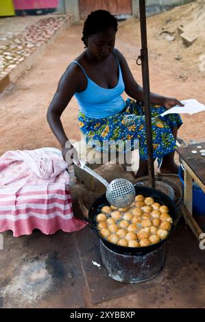 A Burkinabe woman deep frying gateaux ( fried doughnuts ). This is a popular breakfast in Burkina faso and west Africa. Stock Photo