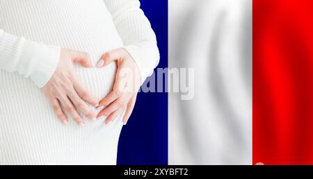 Demographics, pregnancy and love baby in France concept. Pregnant woman making heart against her stomach on French flag background. Stock Photo