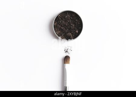 Dark brown face shadow in container and eye shadow or make-up brush. Makeup concept flat lay on white background Stock Photo