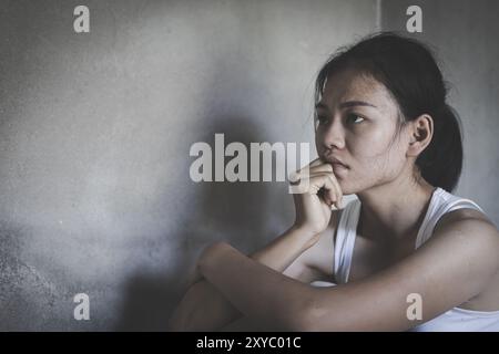 Depressed woman, person sitting alone on the floor felling sad worry. Stress, suicidal thoughts. Stock Photo
