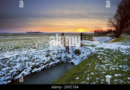 Dramatic sunset over typical Dutch farmland in winter Stock Photo
